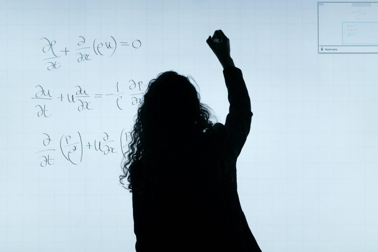 A Silhouette writing equations on a whiteboard