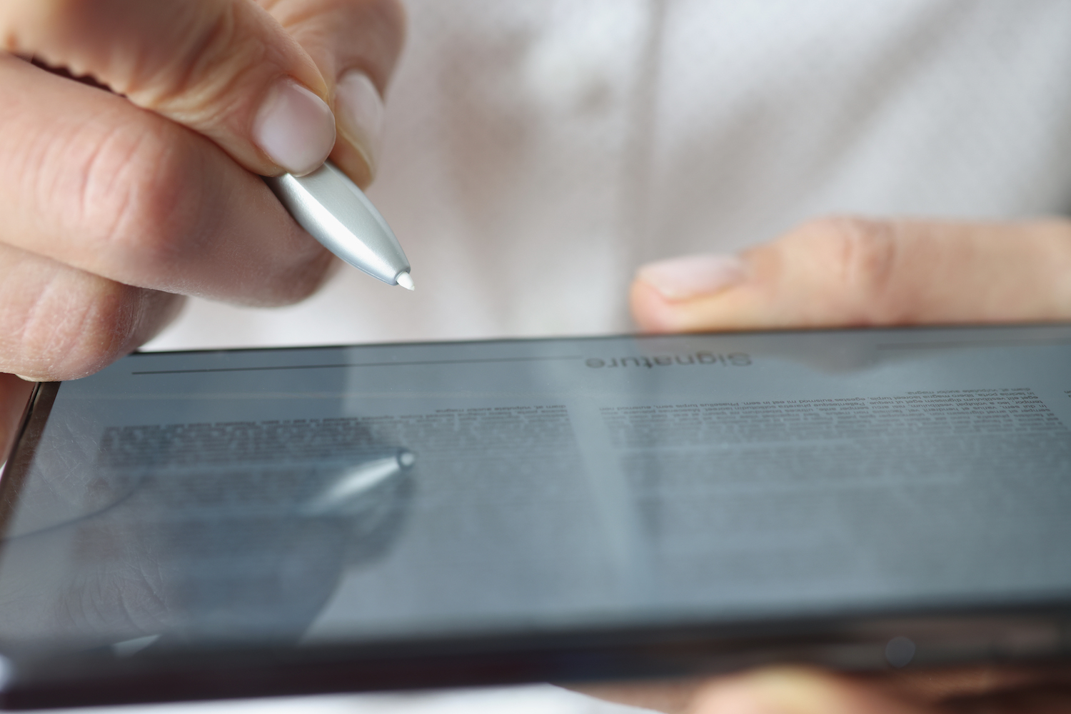 Picture of an iPad being held and a stylus pen being used to operate it