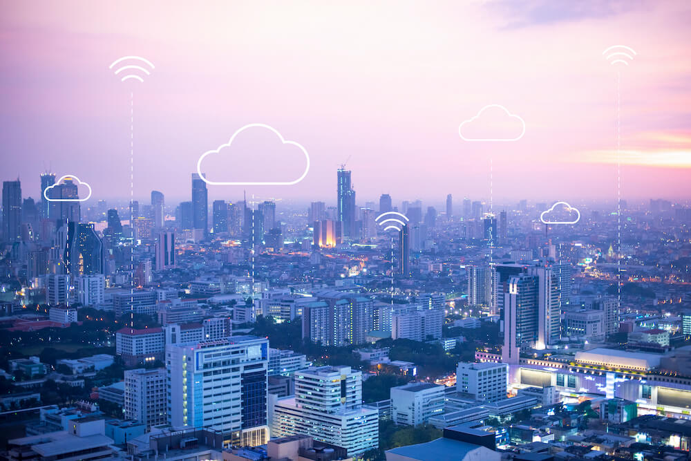 City skyline with electronic cloud symbols floating above