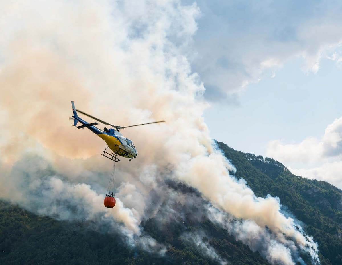 Saab POSeidon Firefighting Helicopter Flying over Smoking Mountains