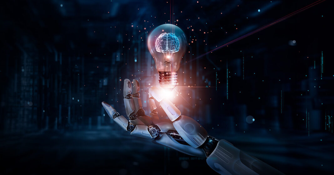 A futuristic digital illustration showing a robotic hand holding a glowing lightbulb floating on the top of it. The lightbulb contains a brain-shaped design, symbolizing artificial intelligence. The background features a dark blue, high-tech environment with digital data patterns and glowing network connections.