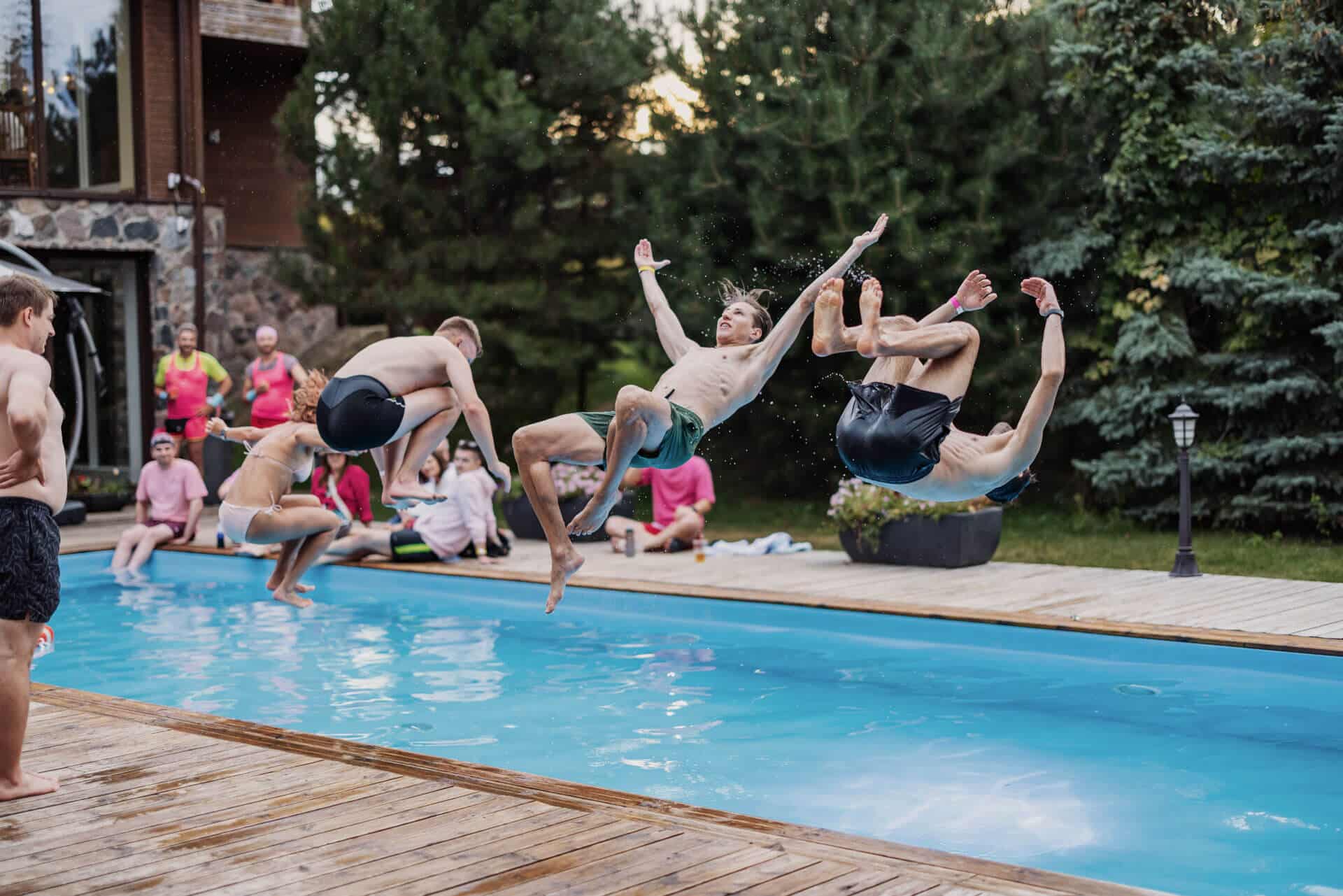 A group of Zenitech employees jumping into a swimming pool