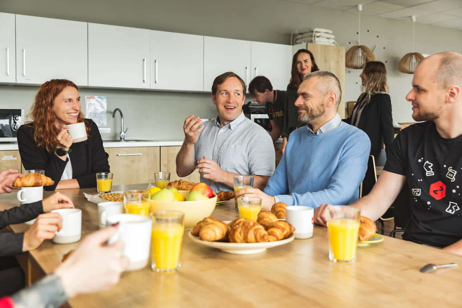 A group of Zenitech employees sitting around a table with breakfast