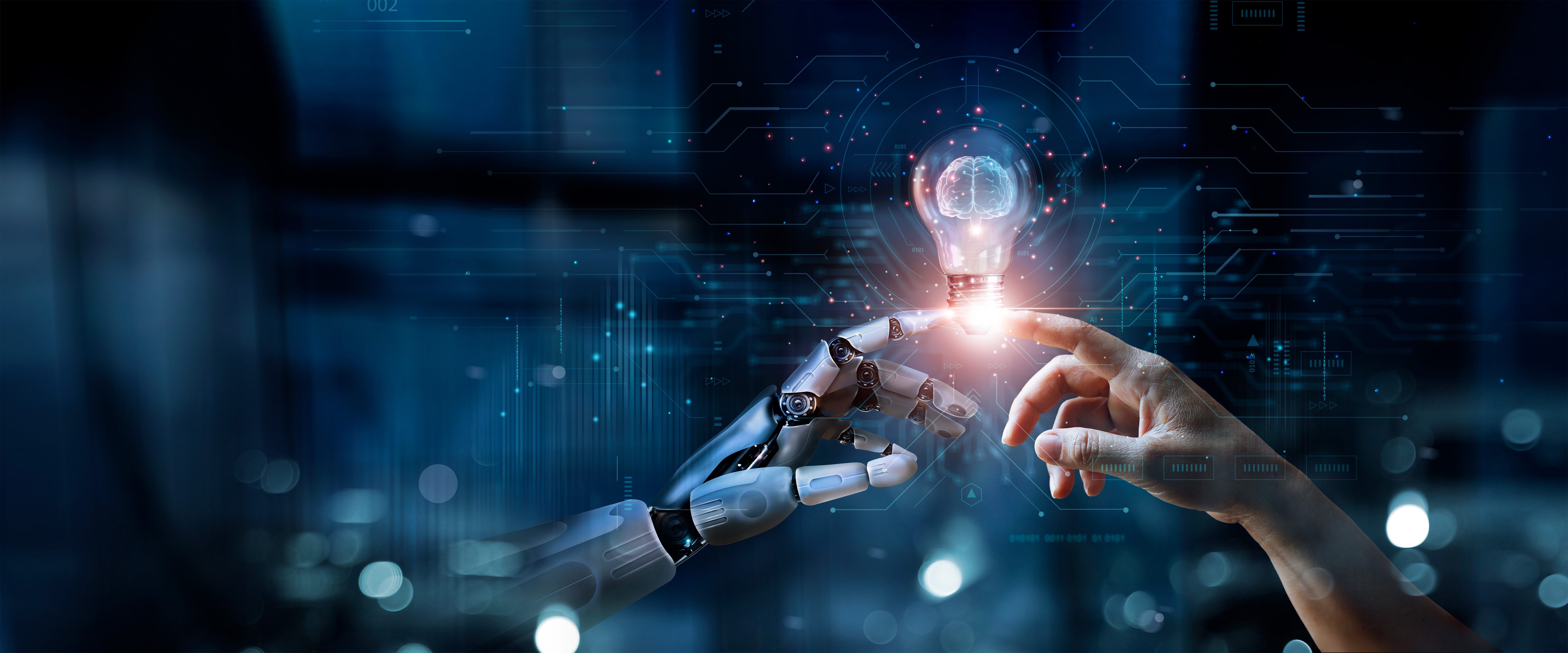 A futuristic digital illustration showing a robotic hand and a human hand touching fingertips, with a glowing lightbulb floating between them. The lightbulb contains a brain-shaped design, symbolizing artificial intelligence and human collaboration. The background features a dark blue, high-tech environment with digital data patterns and glowing network connections.