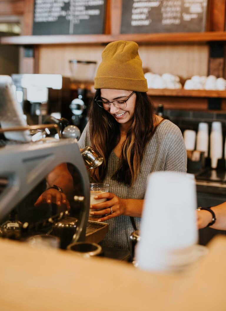 Woman wearing orange hat working in a coffee shop