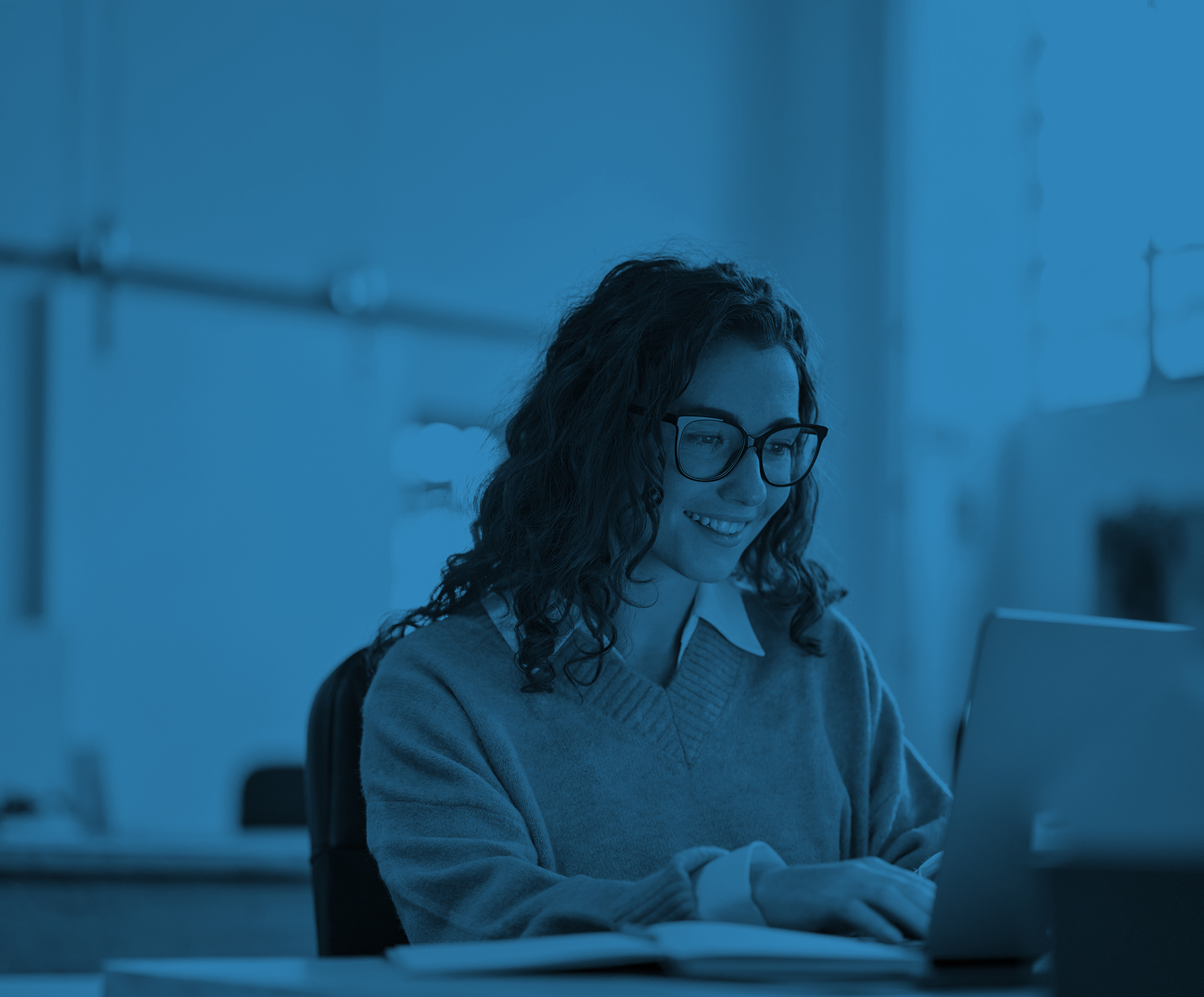 Young woman sat at a desk, researching online